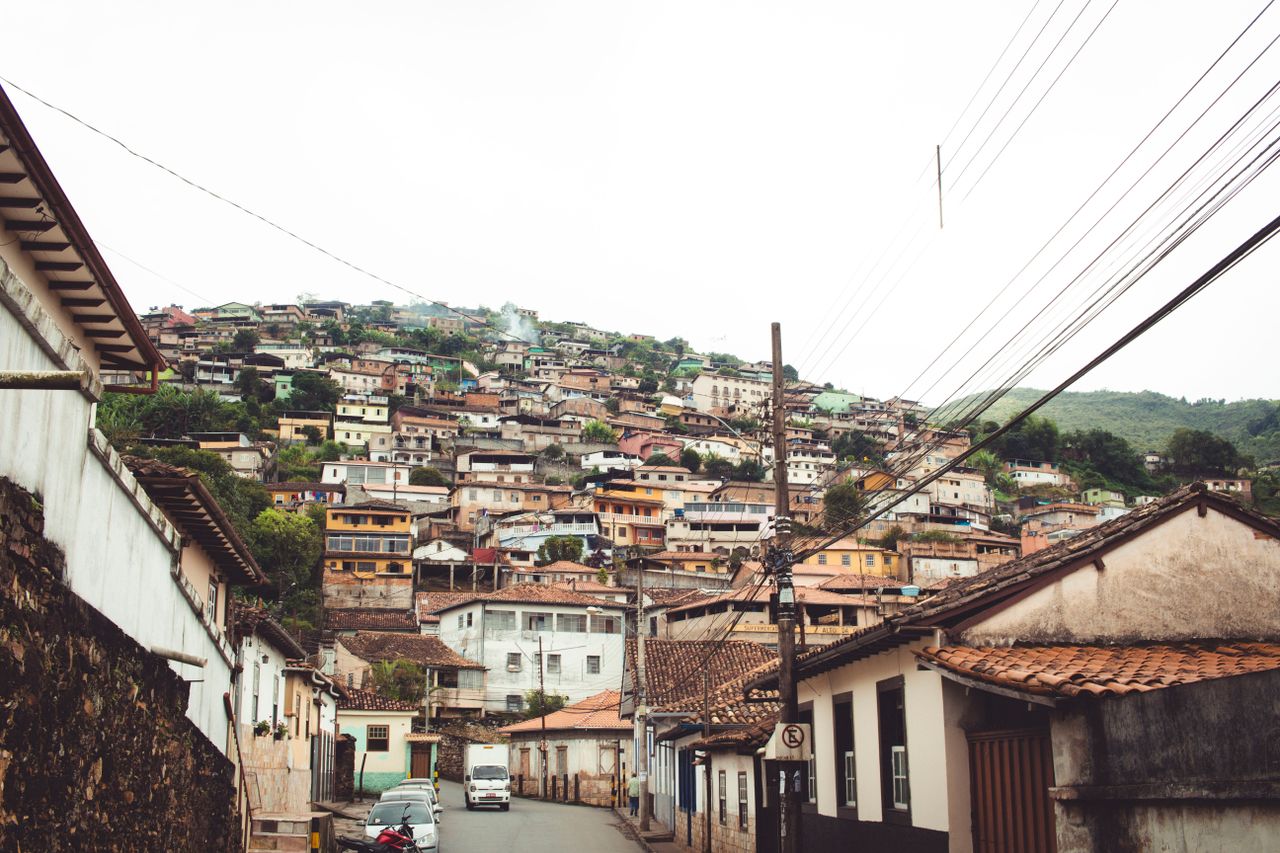 contact-img Charming street view of Ouro Preto, showcasing traditional architecture on a hillside.